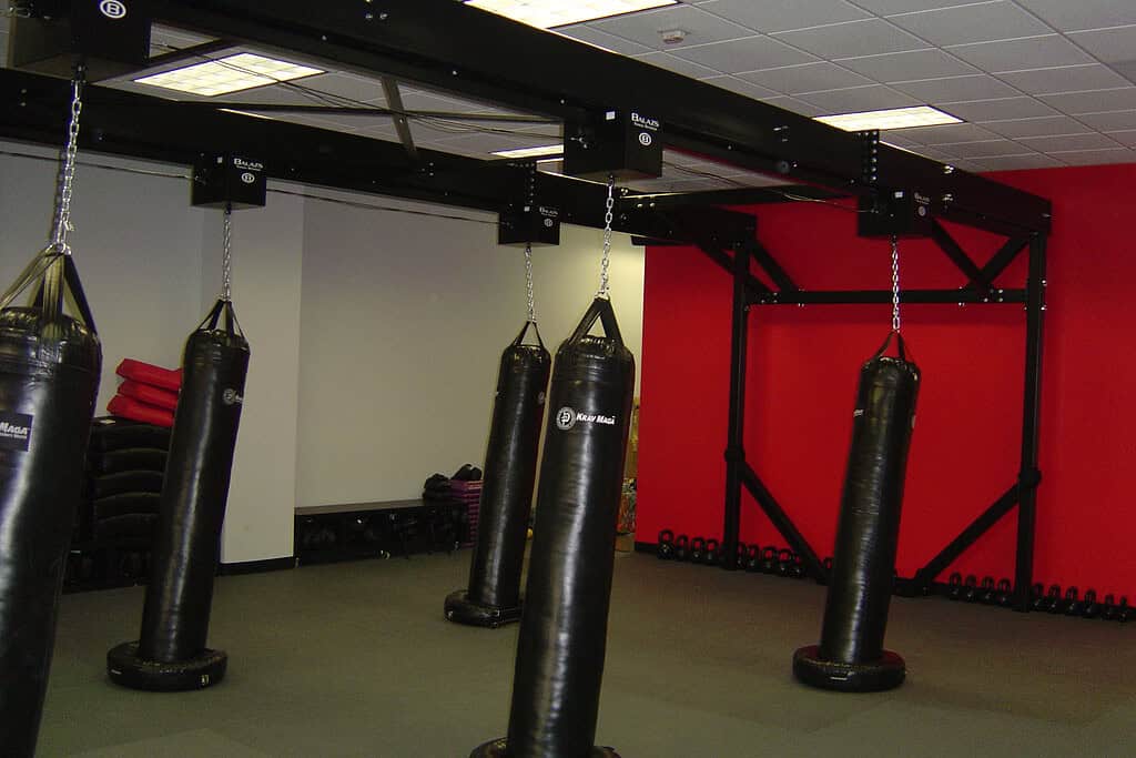 Custom floor-mounted free-standing Balazs frame supporting Ultra-Trak with heavy bags in a studio with a red accent wall