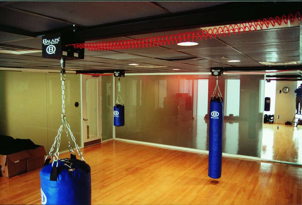 Blue Balazs heavy bags deployed on an Ultra-Trak ceiling track in a bright community centre studio