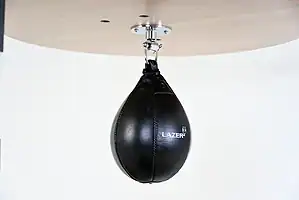 Black Balazs Lazer 11 x 8 inch large speed bag, Lazer-logo view, mounted beneath a wooden platform
