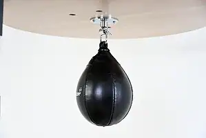 Black Balazs Lazer 11 x 8 inch large speed bag, side view, mounted beneath a wooden platform