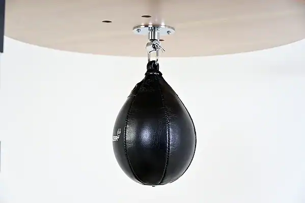 Black Balazs Lazer 11 x 8 inch large speed bag, side view, mounted beneath a wooden platform