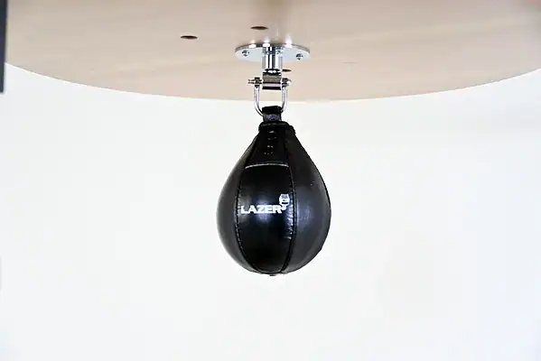 Black Balazs Lazer 8 x 5 inch peanut speed bag, Lazer-logo view, mounted beneath a wooden platform