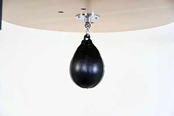 Black Balazs Lazer 8 x 5 inch peanut speed bag, side view, mounted beneath a wooden platform