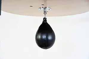 Black Balazs Lazer 9 x 6 inch small speed bag, side view, mounted beneath a wooden platform