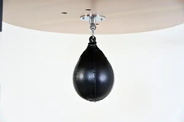 Black Balazs Lazer 9 x 6 inch small speed bag, side view, mounted beneath a wooden platform